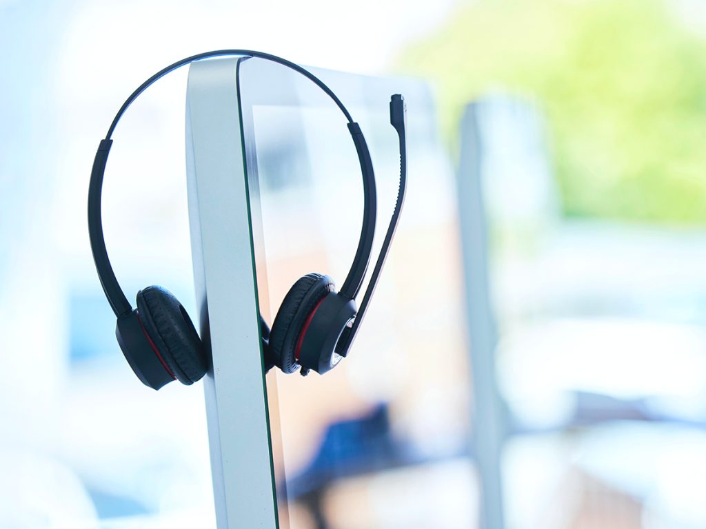 Voice over IP headset hanging on a computer monitor